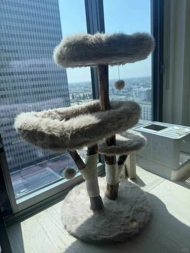 Luxury gray natural wood cat tree beside floor-to-ceiling city windows